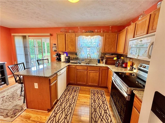 155 Page Farm Rd, Mount Airy, NC 27030 - kitchen featuring a peninsula, a sink, light wood-type flooring, a textured ceiling, and white appliances