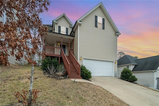 front of property with a garage, a porch, and a lawn