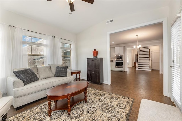 7722 NW Meadows Dr, Stokesdale, NC 27357 - living area with a ceiling fan, dark wood-style floors, vaulted ceiling, stairway, and crown molding