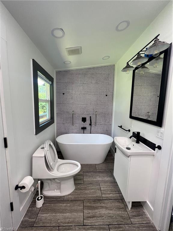 2042 Harrison Ave, Winston-Salem, NC 27105 - bathroom with a freestanding tub, vanity, and wood tiled floors