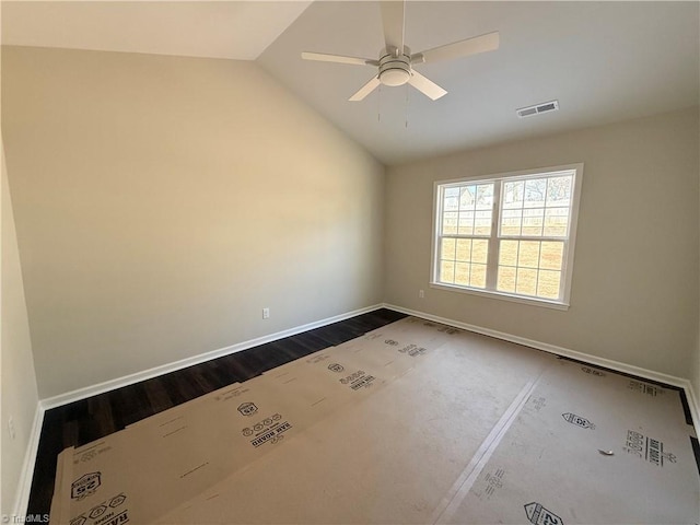 unfurnished room with visible vents, vaulted ceiling, ceiling fan, wood finished floors, and baseboards