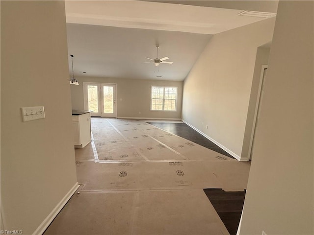 interior space featuring vaulted ceiling and baseboards