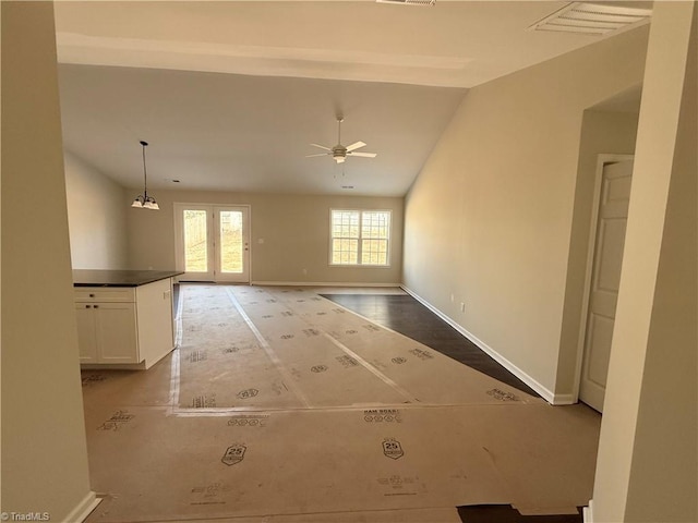 empty room with a ceiling fan, lofted ceiling, visible vents, and baseboards