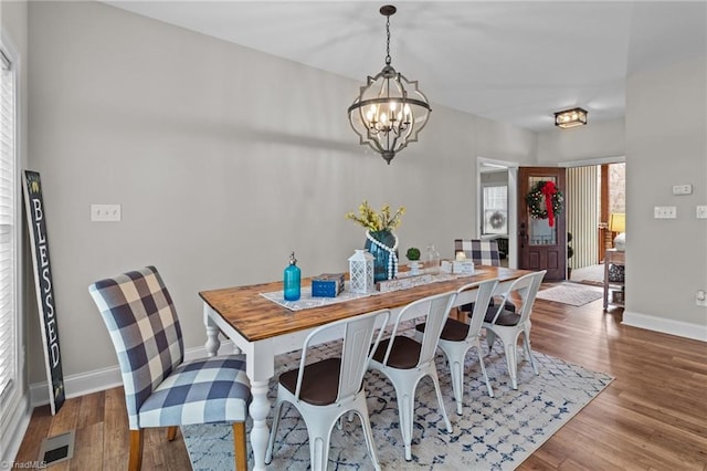 dining space with a notable chandelier and hardwood / wood-style flooring