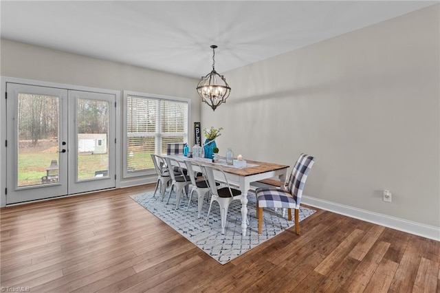 dining space with french doors, a notable chandelier, and hardwood / wood-style flooring