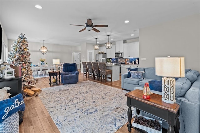 living room featuring ceiling fan and light wood-type flooring