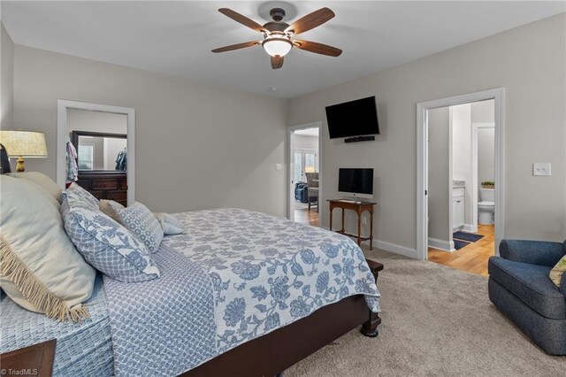 carpeted bedroom featuring ensuite bath and ceiling fan