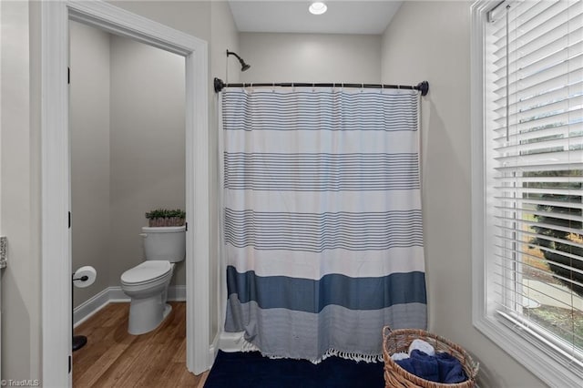 bathroom with curtained shower, toilet, and wood-type flooring