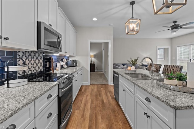 kitchen with white cabinetry, sink, ceiling fan, wood-type flooring, and appliances with stainless steel finishes