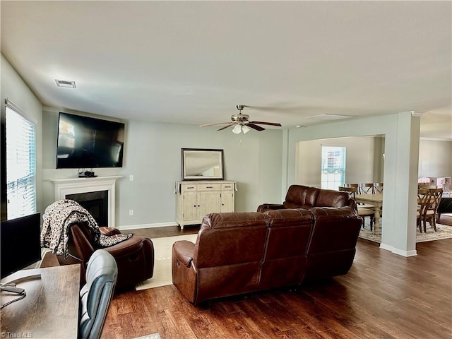 living room featuring a healthy amount of sunlight, dark hardwood / wood-style flooring, and ceiling fan