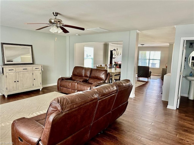 living room with ceiling fan and dark wood-type flooring