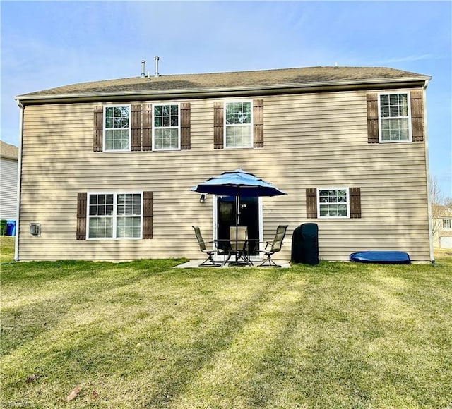 rear view of house featuring a patio and a yard