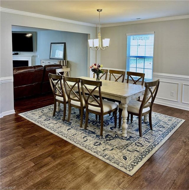 dining area featuring a chandelier, crown molding, and dark hardwood / wood-style floors