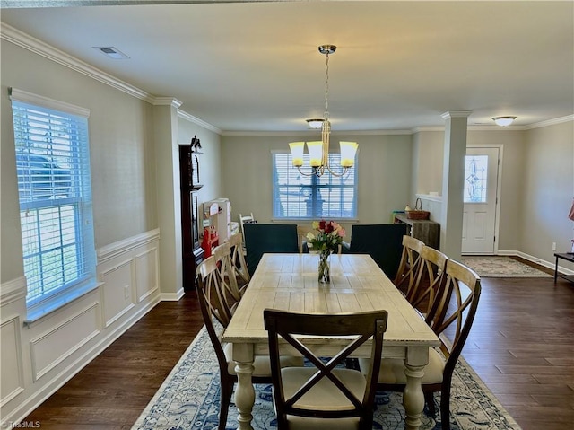 dining space featuring a healthy amount of sunlight, ornamental molding, dark hardwood / wood-style flooring, and a notable chandelier