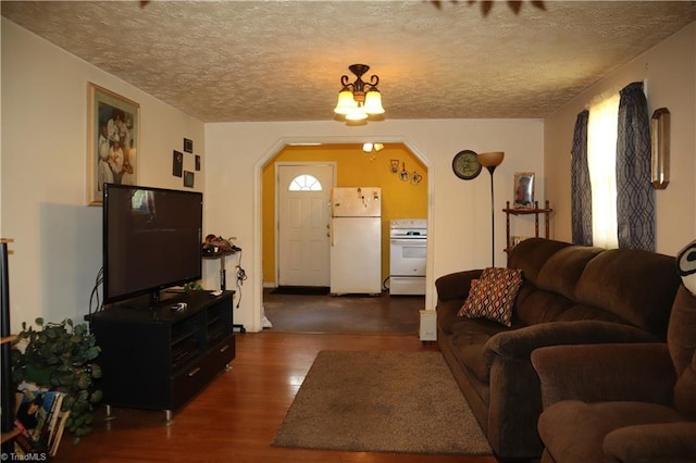 84 Sol Nunnally Rd, Pelham, NC 27311 - living room with dark wood-style floors, arched walkways, a textured ceiling, and plenty of natural light