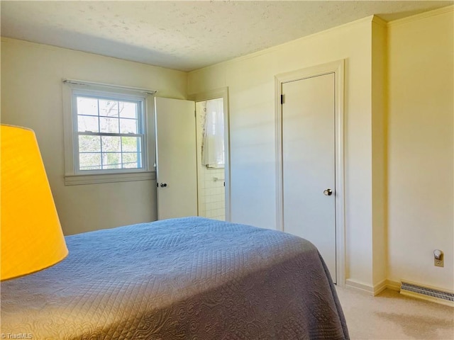 bedroom with baseboards, light colored carpet, visible vents, and a textured ceiling