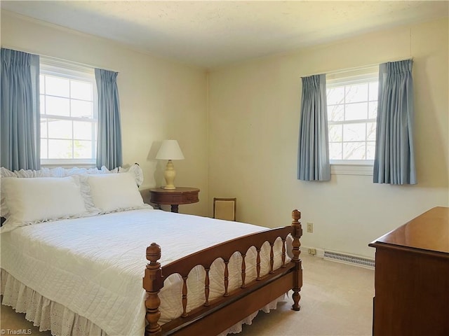 bedroom with a baseboard heating unit, baseboards, and carpet floors