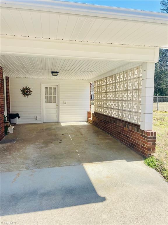 garage featuring a carport and fence