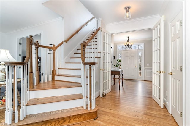 foyer entrance with crown molding and light wood-type flooring