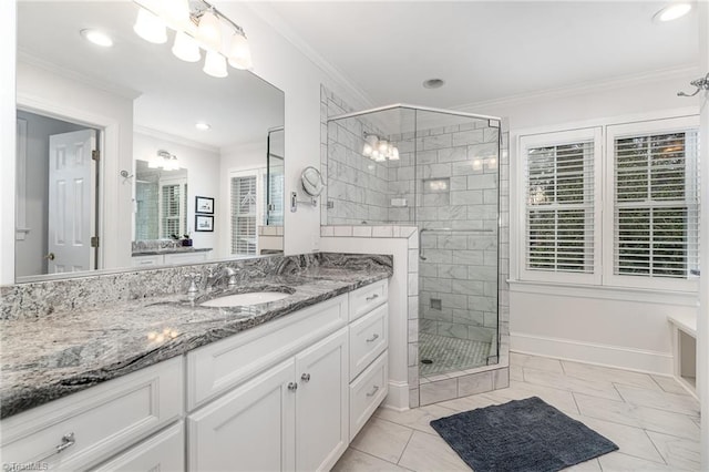 bathroom featuring vanity, a shower with shower door, and ornamental molding