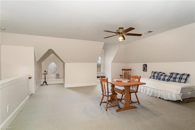 carpeted dining space with vaulted ceiling, ceiling fan, and plenty of natural light