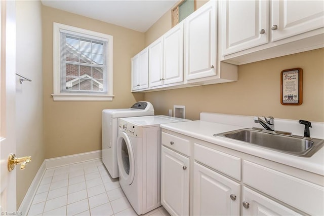 laundry room with cabinets, sink, light tile patterned floors, and washing machine and clothes dryer