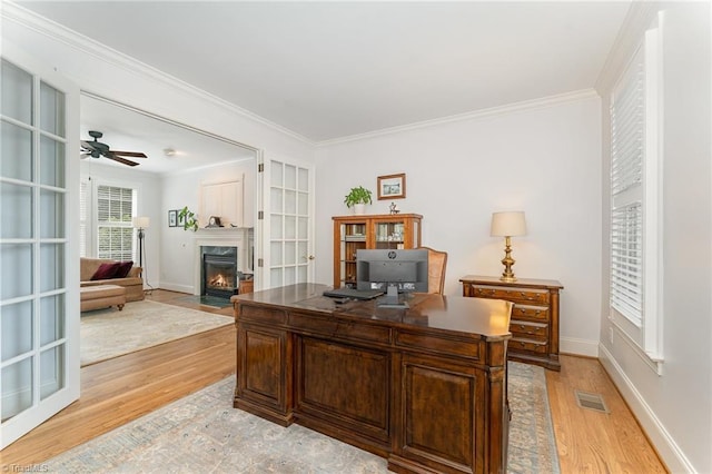 office area featuring crown molding, a high end fireplace, and light hardwood / wood-style flooring