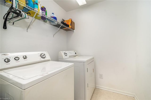 laundry area with light tile patterned floors and washing machine and clothes dryer