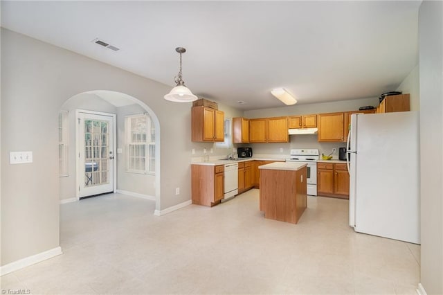 kitchen featuring a kitchen island, decorative light fixtures, and white appliances