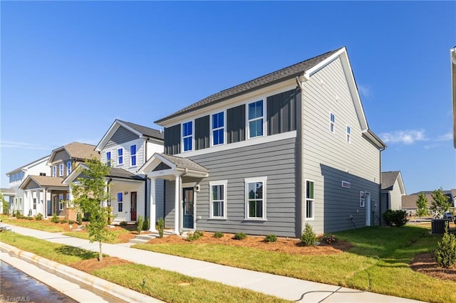 view of front of home featuring central AC and a front lawn