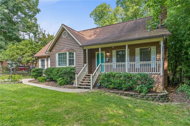 view of front of house with a front yard and covered porch