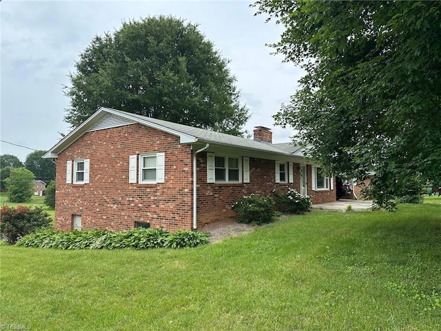 5912 US Highway 21, Jonesville, NC 28642 - view of side of home featuring a chimney, brick siding, and a lawn