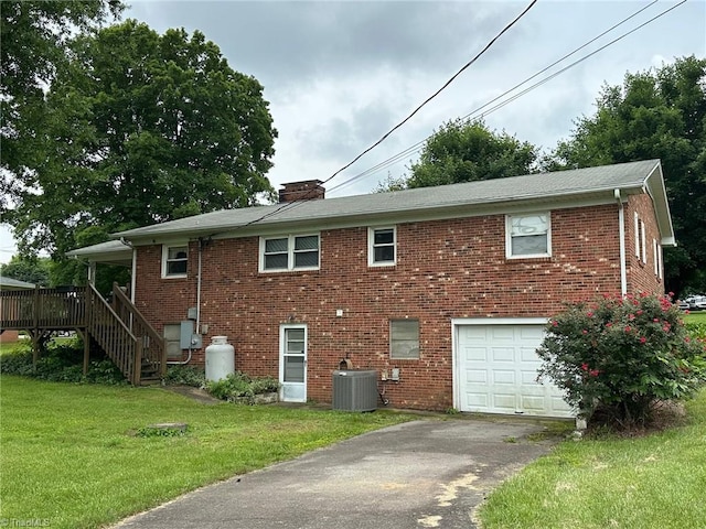 5912 US Highway 21, Jonesville, NC 28642 - rear view of house with a garage, cooling unit, a lawn, and brick siding