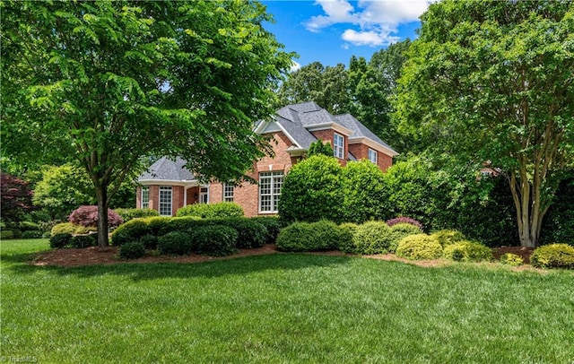 view of side of property featuring brick siding and a yard