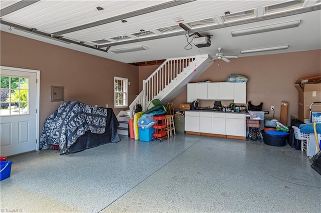 garage featuring electric panel, a garage door opener, and a ceiling fan