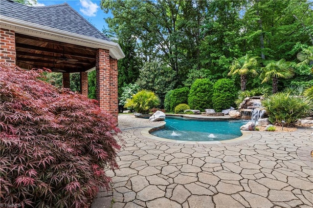 outdoor pool featuring ceiling fan and a patio