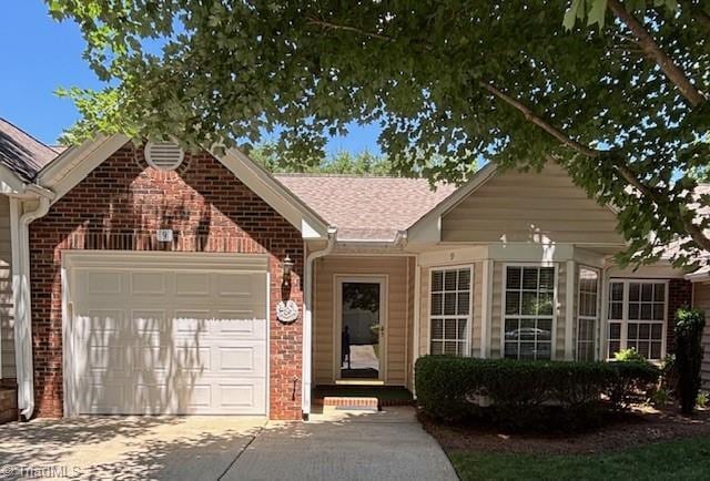 9 Whitdale Pt, Greensboro, NC 27455 - ranch-style house featuring an attached garage, brick siding, driveway, and a shingled roof