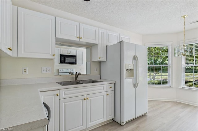 9 Whitdale Pt, Greensboro, NC 27455 - kitchen with black microwave, white refrigerator with ice dispenser, white cabinets, a textured ceiling, and light countertops