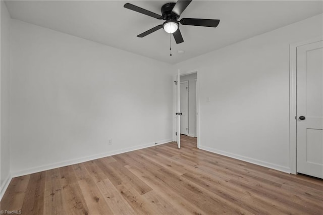 empty room featuring light wood-style flooring, a ceiling fan, and baseboards