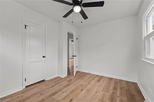 unfurnished bedroom with a ceiling fan, baseboards, and light wood finished floors