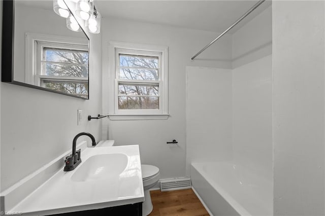 full bathroom featuring vanity, wood finished floors, visible vents, shower / bath combination, and toilet