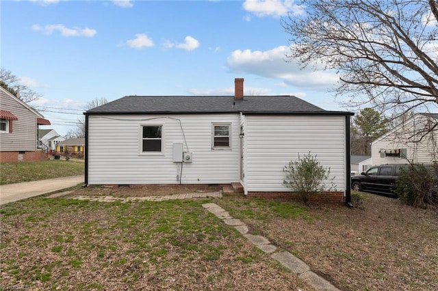 rear view of house with a yard, a chimney, and crawl space