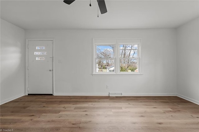 foyer entrance with visible vents, baseboards, wood finished floors, and a ceiling fan