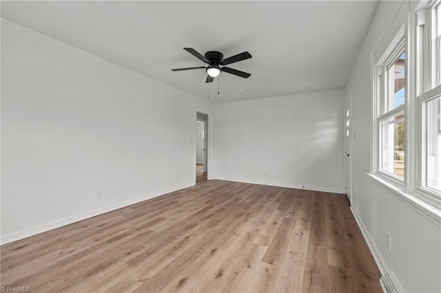 empty room with light wood-type flooring, baseboards, and a ceiling fan