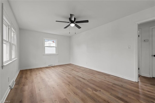 spare room featuring a ceiling fan, wood finished floors, and baseboards