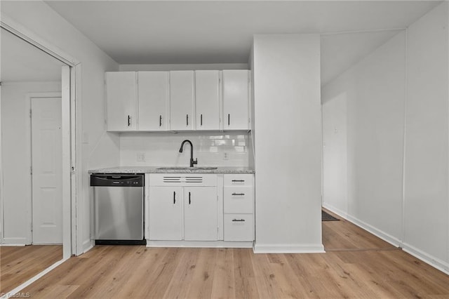 kitchen with light wood finished floors, a sink, white cabinetry, and stainless steel dishwasher