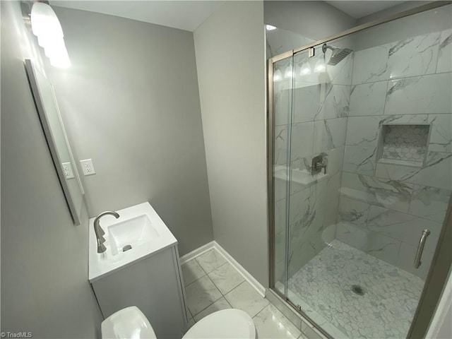 bathroom with a shower with door, vanity, and toilet