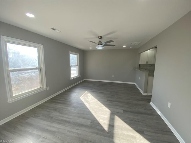 unfurnished living room with dark wood-type flooring and ceiling fan