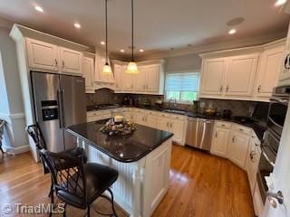 105 Finborough Ct, Kernersville, NC 27284 - kitchen featuring tasteful backsplash, wood finished floors, a kitchen breakfast bar, and stainless steel appliances