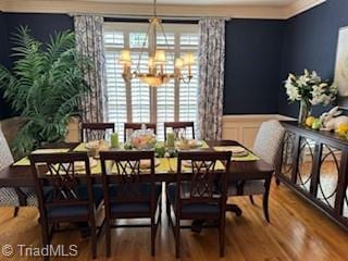 105 Finborough Ct, Kernersville, NC 27284 - dining area with a wainscoted wall, wood finished floors, an inviting chandelier, and a decorative wall